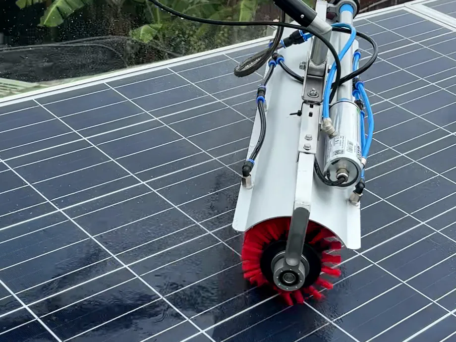 Brosse rotative montée sur perche en train de nettoyer un panneau photovoltaïque mouillé à l’eau osmosée